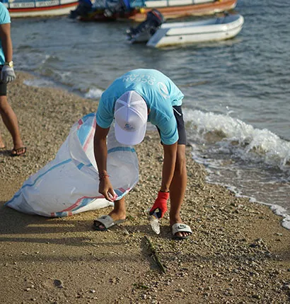 A volunteer picking up trash in the beach